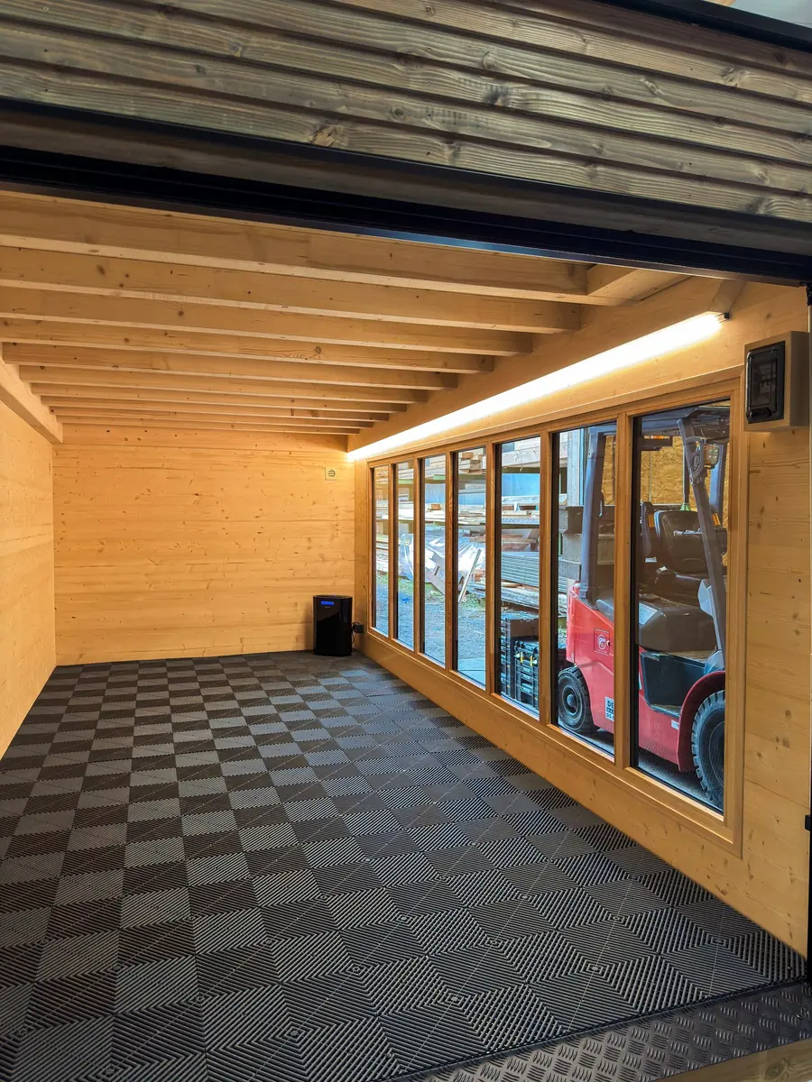 Intérieur d'un garage Inno'Kub terminé : dalles de sol, châssis vitrés et bandeau LED