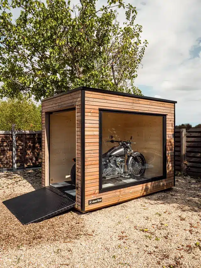 Abri moto Mono 125 à châssis vitré sur une cour gravillonnée, cruiser exposé