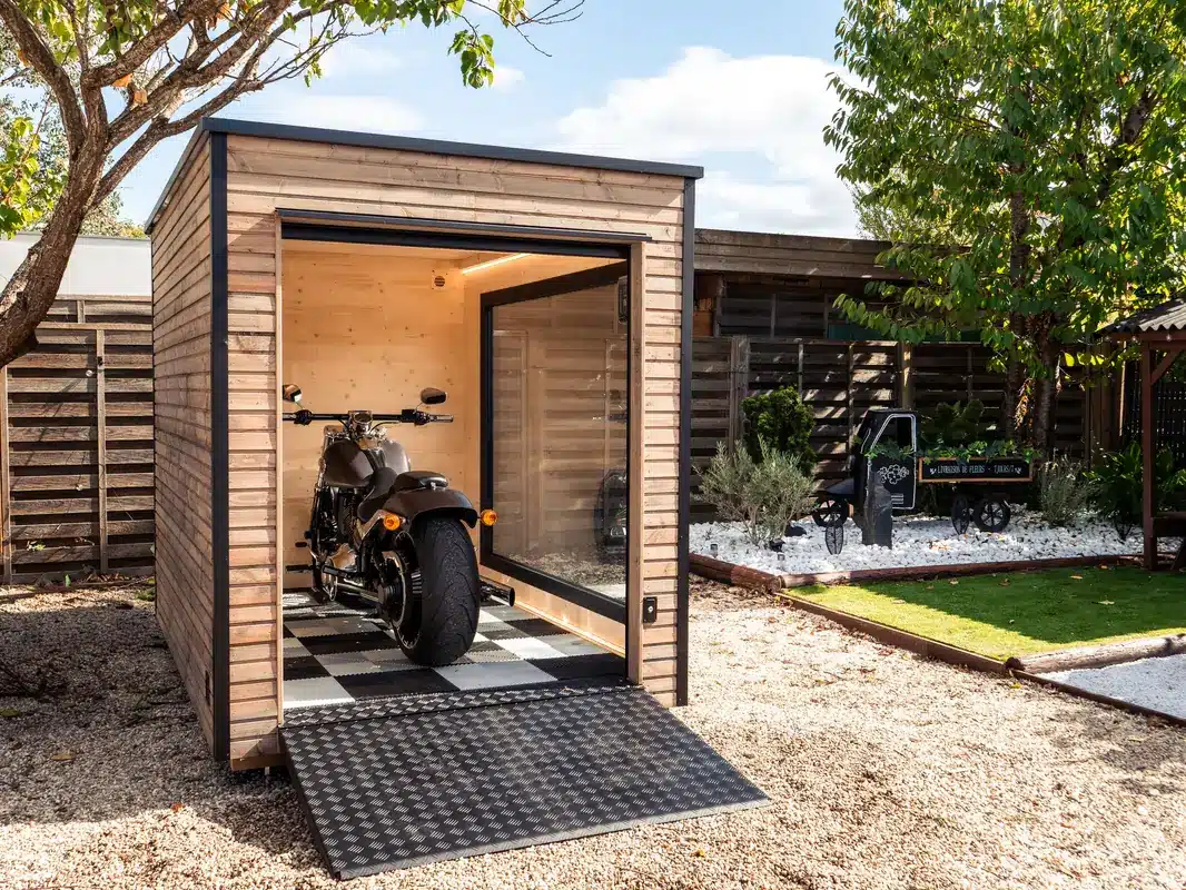 Abri moto Inno'Kub porte ouverte, moto vue de l'arrière sur dalles de sol en damier