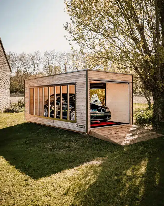 Garage en bois Inno'Kub à huit vitrages installé dans un jardin, coupé BMW Z3 à l'intérieur