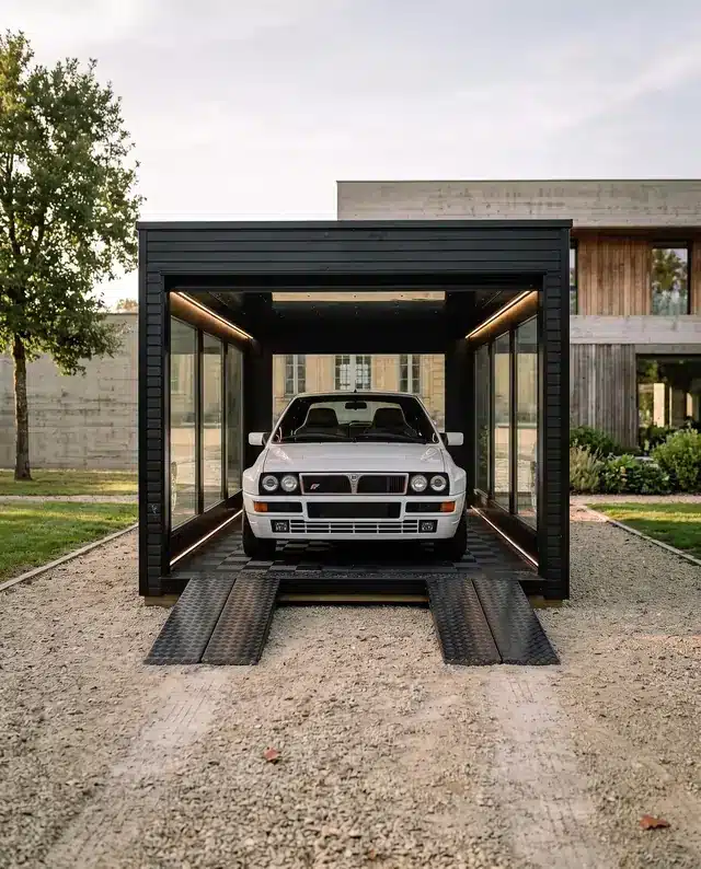 Garage Obsidian devant une maison contemporaine, Lancia Delta blanche exposée